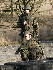 Boy gets punished by two soldiers